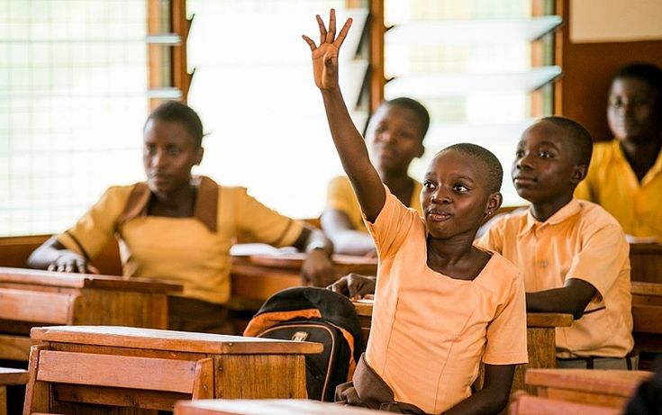 A learner raising her hand during a classroom lesson